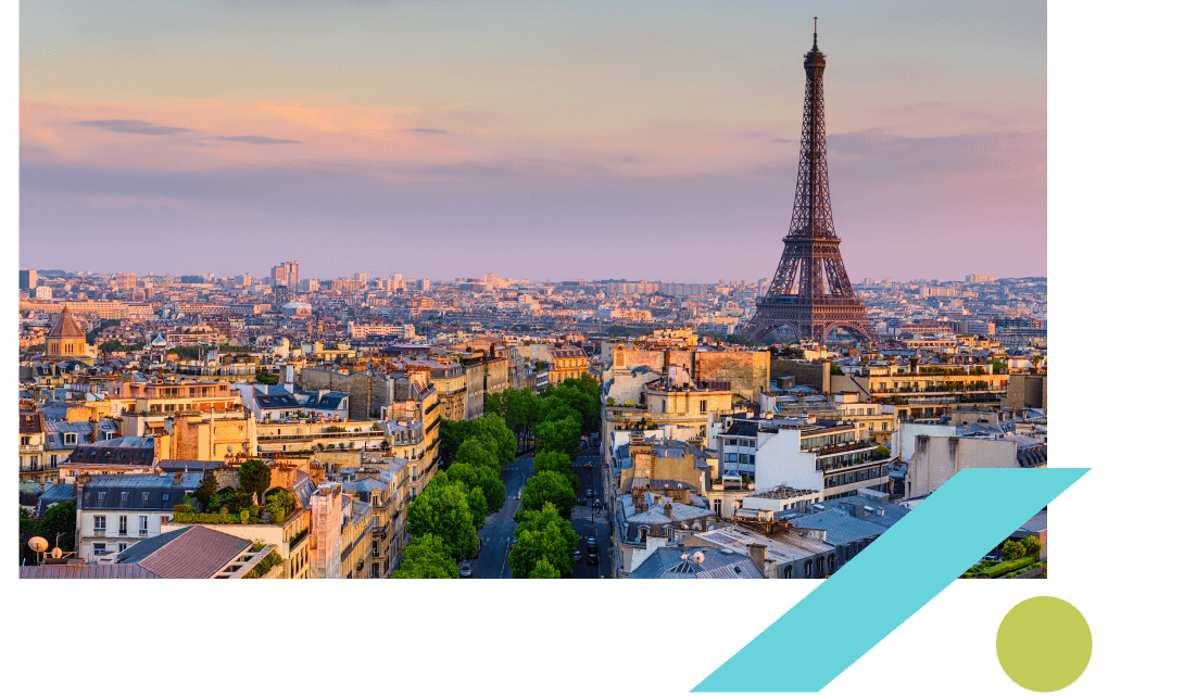 View of the Paris skyline at sunset with the Eiffel Tower to the right. 