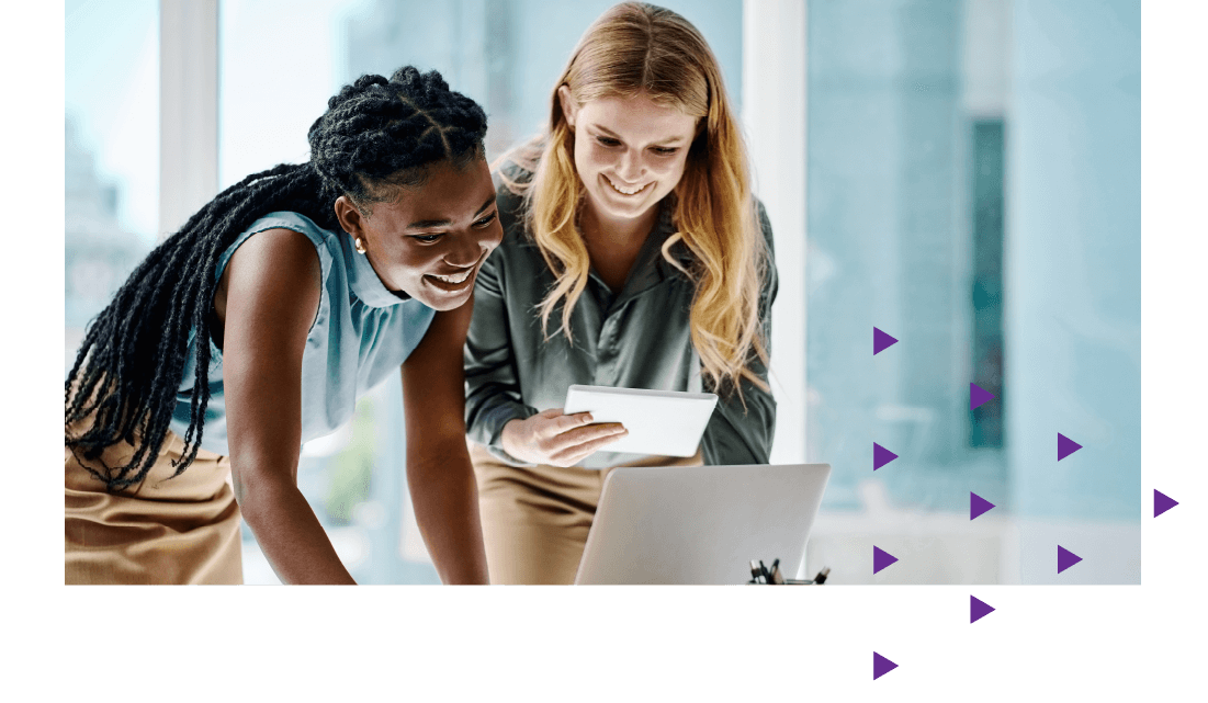 Two women looking at a laptop and smiling. 