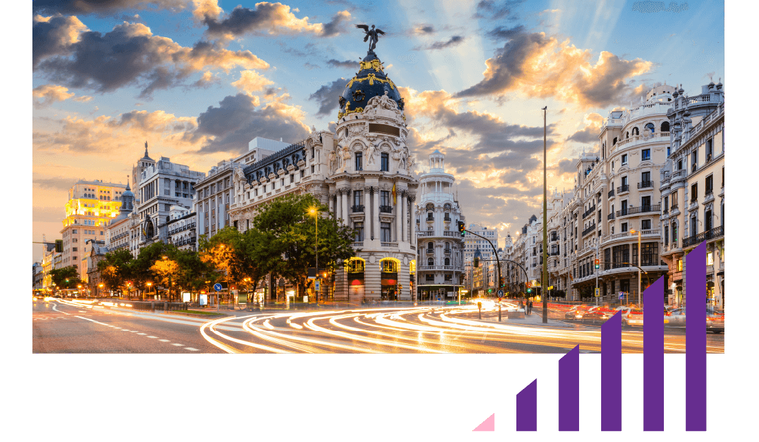 A busy city scene at sunset with grand old buildings in view. 