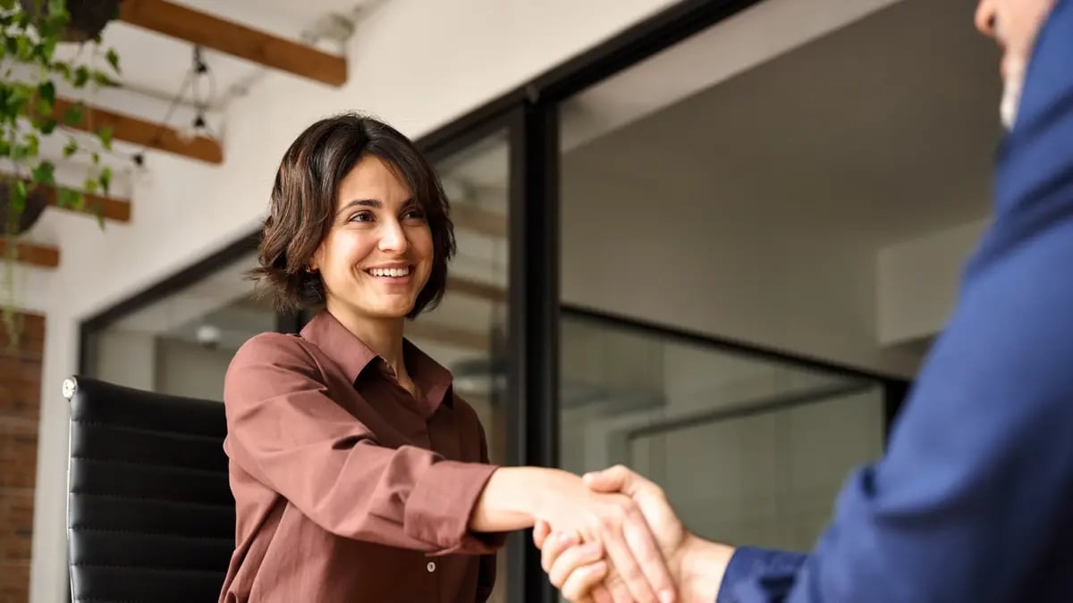 Two people happily shaking hands in a way that suggests they've agreed to a partnership.