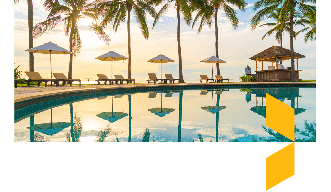 Swimming pool at sunset with sun loungers and palm trees around the edge. Swimming pool at sunset with sun loungers and palm trees around the edge.