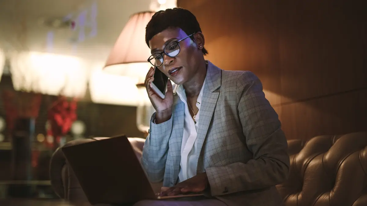 A woman talking over the phone in a dark room.