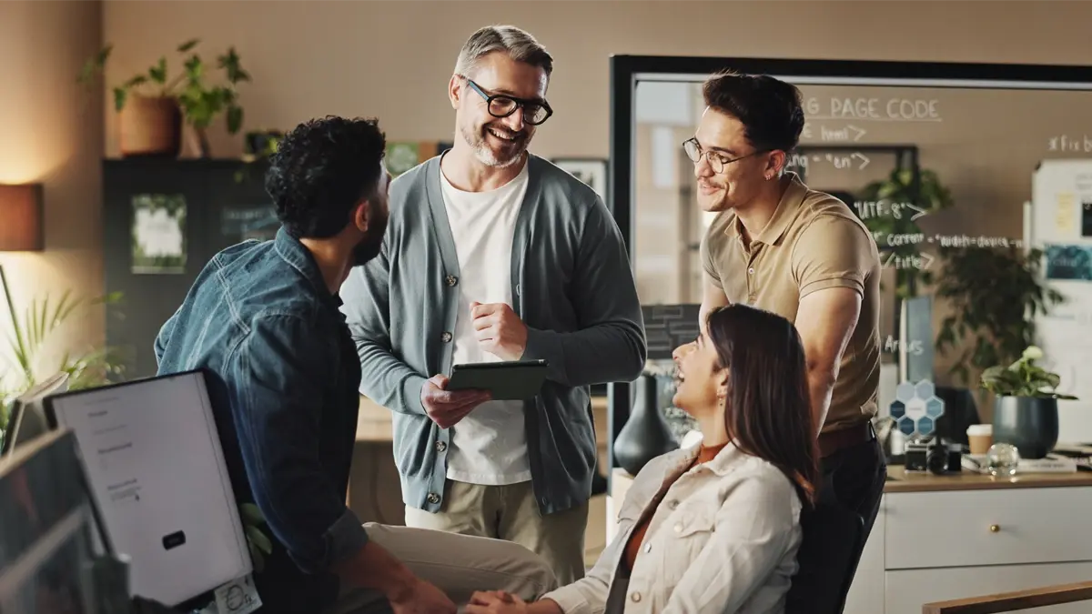 A group of people having a discussion in an office with a few notepads.